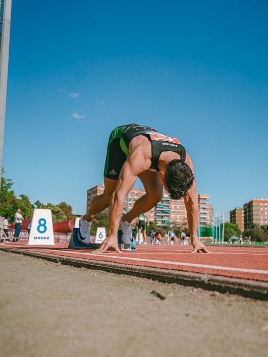 Jose Giner colocándose en los tacos para una carrera de 200 metros